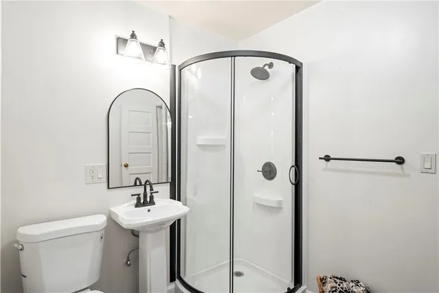 a bathroom with a sink and mirror with toilet