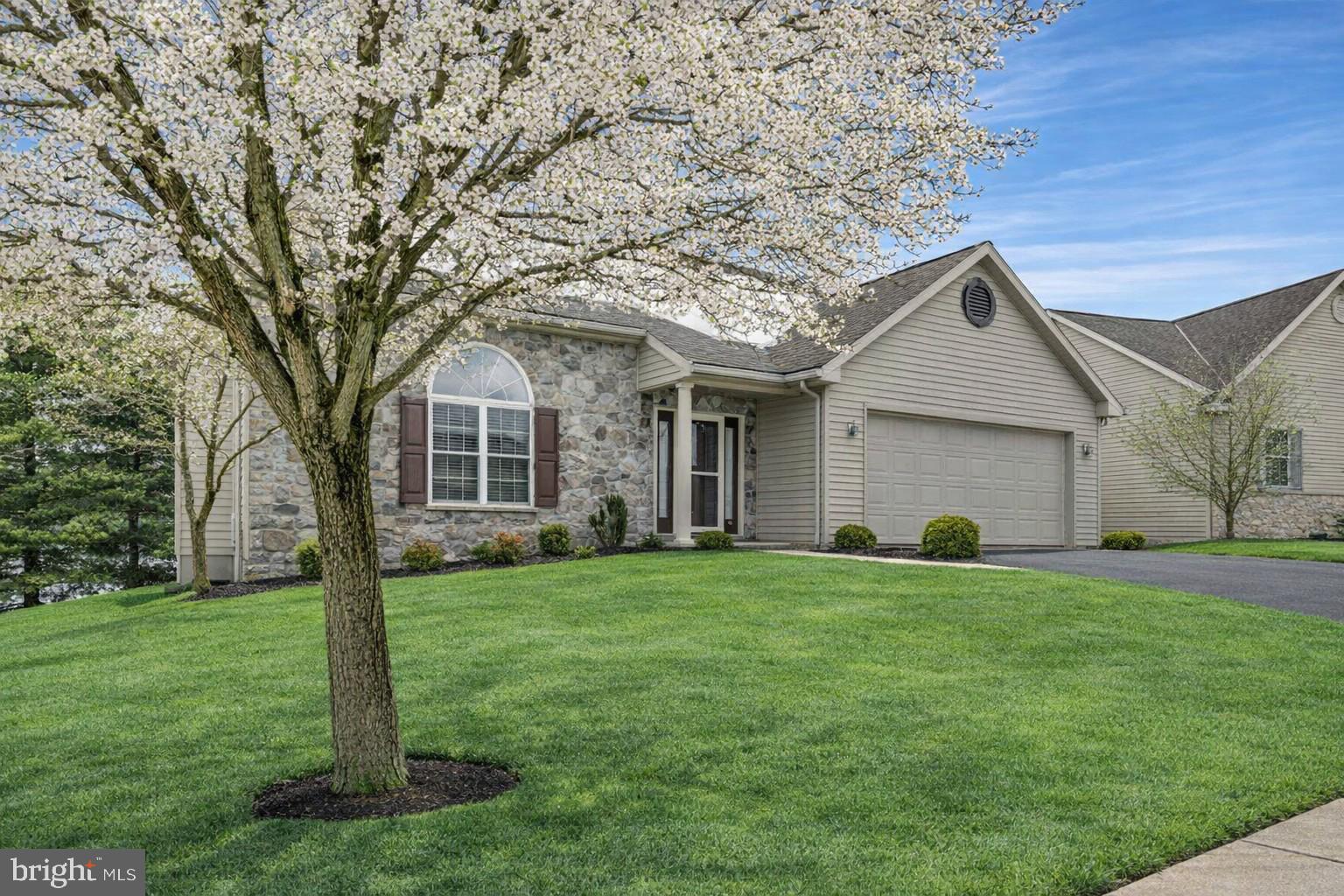 a front view of a house with a garden and yard