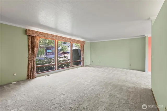 an empty room with floor to ceiling window and an outdoor view