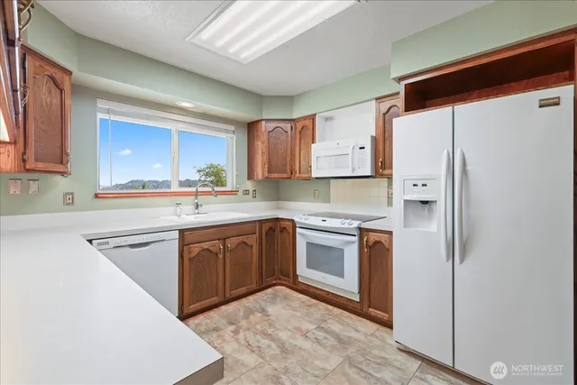a kitchen with stainless steel appliances granite countertop a refrigerator sink and stove