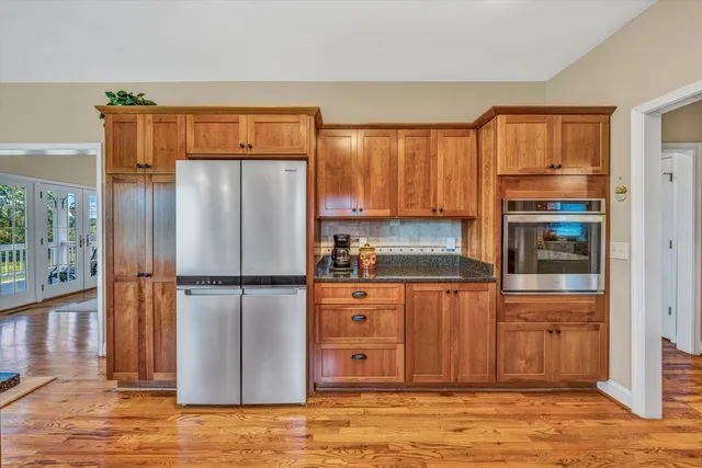 a kitchen with stainless steel appliances granite countertop a refrigerator and a stove top oven