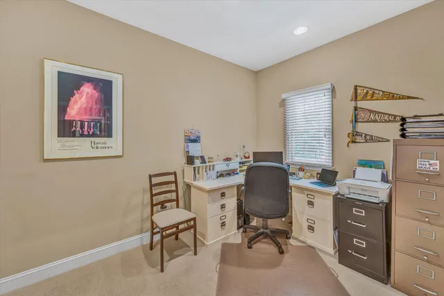 a view of a workspace with furniture and a window