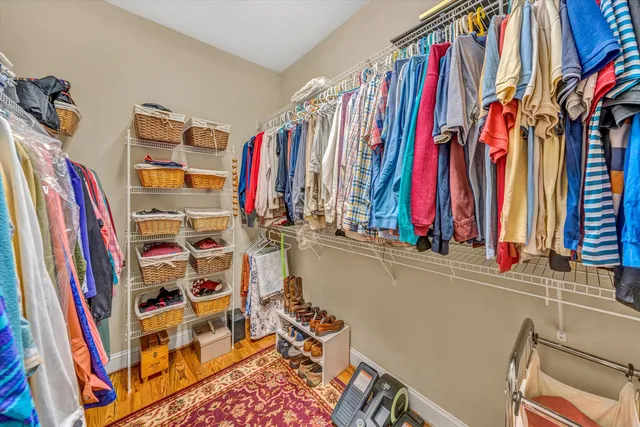 a view of walk in closet with clothes and shoes