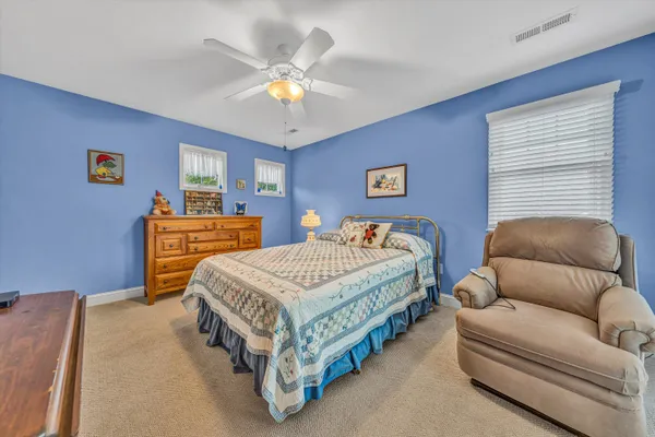 a spacious bedroom with a bed and a chandelier
