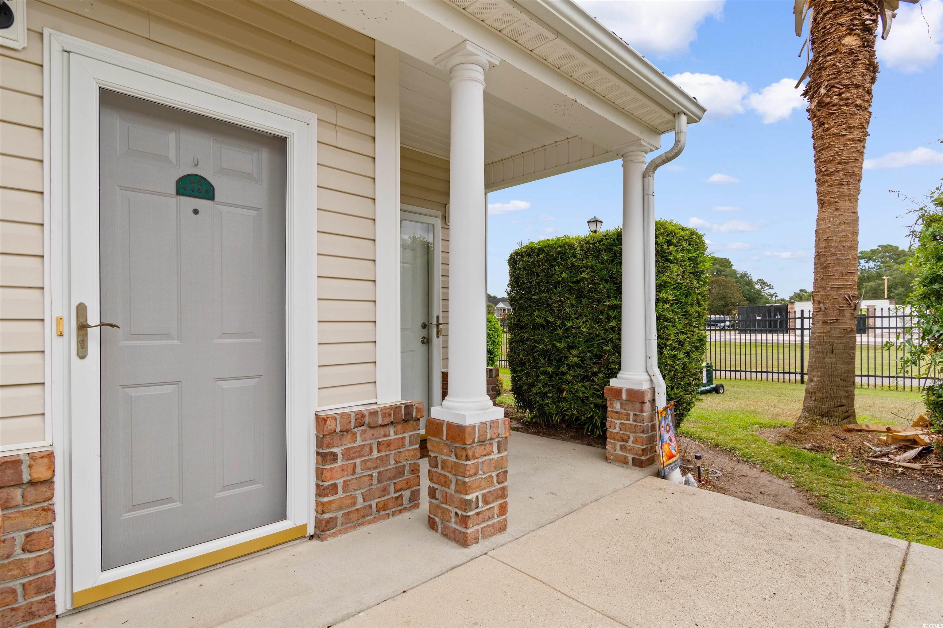4430 Lady Banks Lane, Unit A2 Murrells Inlet, SC 29576 - Photo 3 of 31 View of exterior entry featuring covered porch and brick siding
