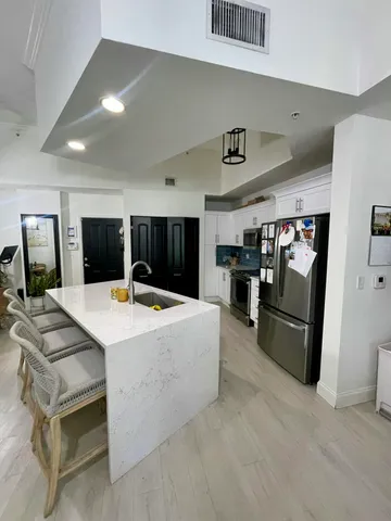 a view of kitchen with stainless steel appliances kitchen island a stove and a refrigerator