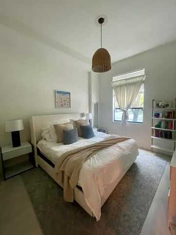 a spacious bedroom with a bed and a large window