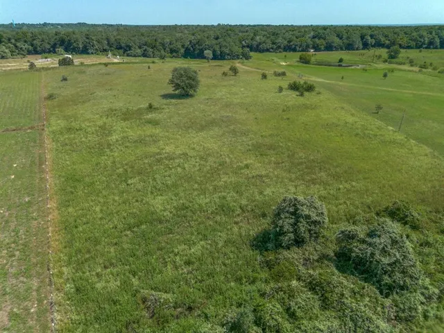 a view of a lake with green field and trees