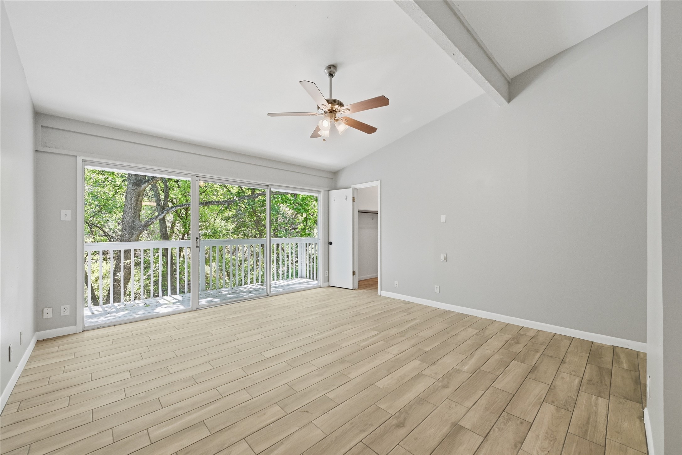 7 Hull Circle Austin, TX 78746 - Photo 5 of 14 Spare room featuring wood tiled floors, ceiling fan, and lofted ceiling with beams