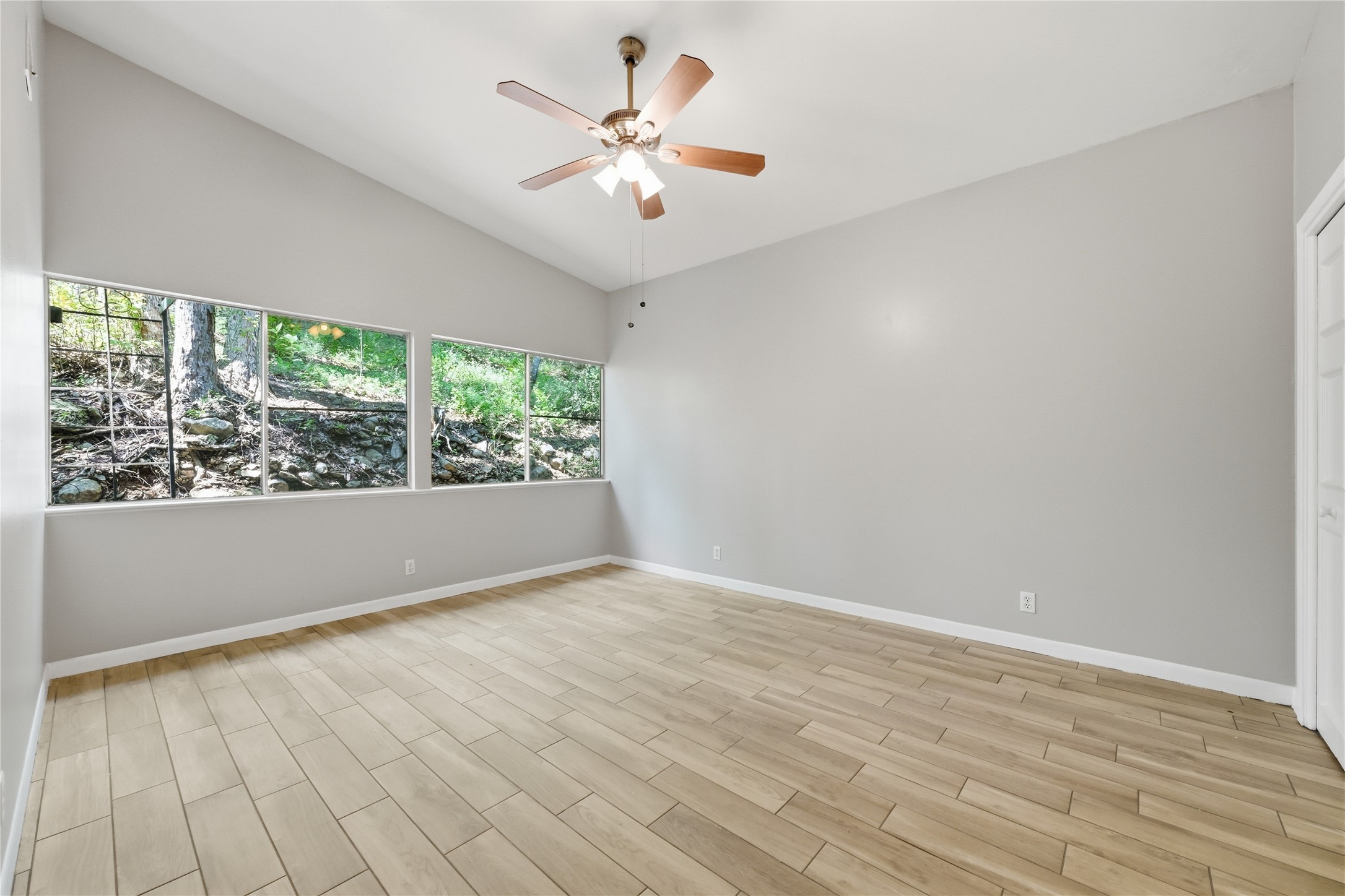 7 Hull Circle Austin, TX 78746 - Photo 7 of 14 Unfurnished room with wood tiled floors, a ceiling fan, and lofted ceiling