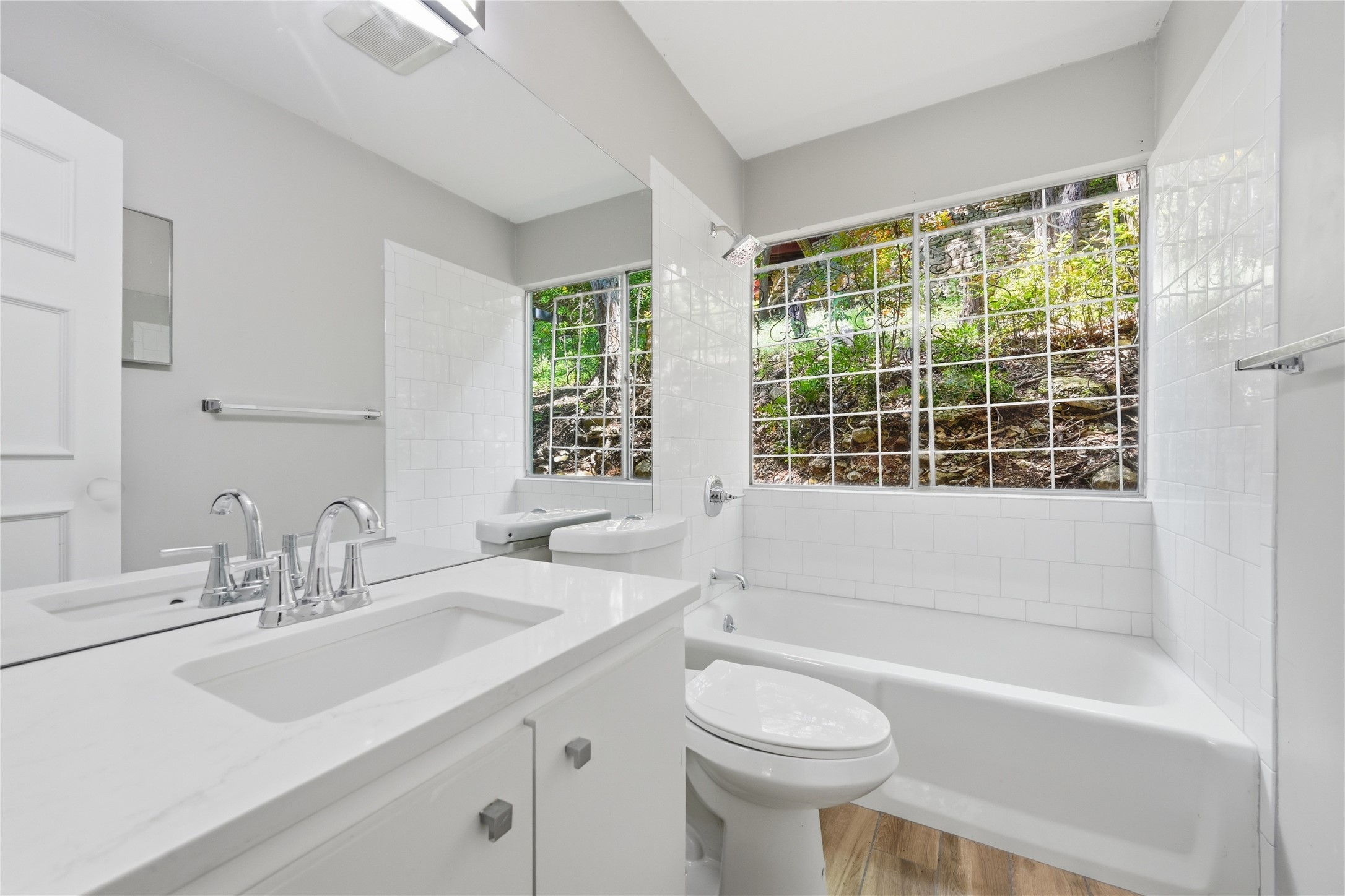 7 Hull Circle Austin, TX 78746 - Photo 9 of 14 Full bathroom featuring vanity, a bathtub, and light wood-style flooring