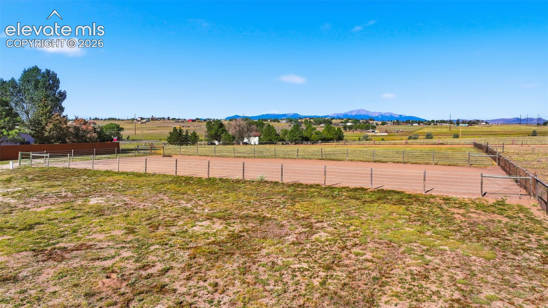 6015 West Condor Road Peyton, CO 80831 - Photo 8 of 50 Expansive outdoor arena with post and rail fencing, surrounded by open land