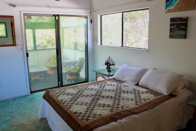 a bed sitting in a bedroom next to a window