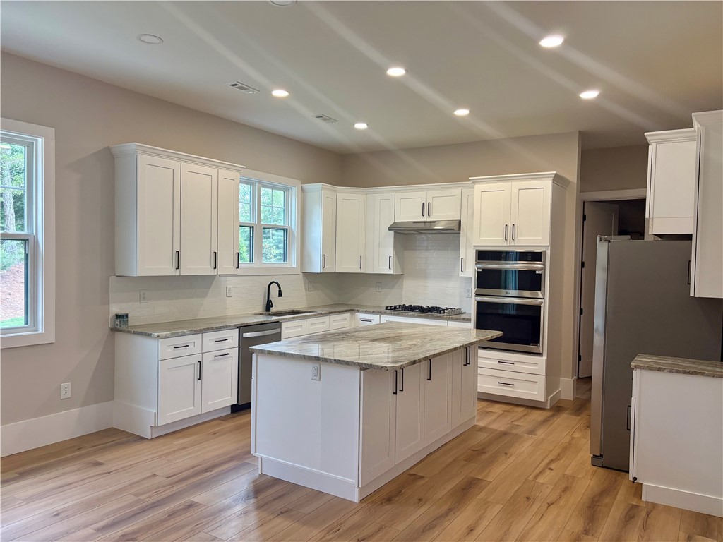 854 Perkins Creek Road Seneca, SC 29678 - Photo 24 of 34 Elegant recessed lighting illuminates this gourmet kitchen featuring premium stone countertops and a central island.