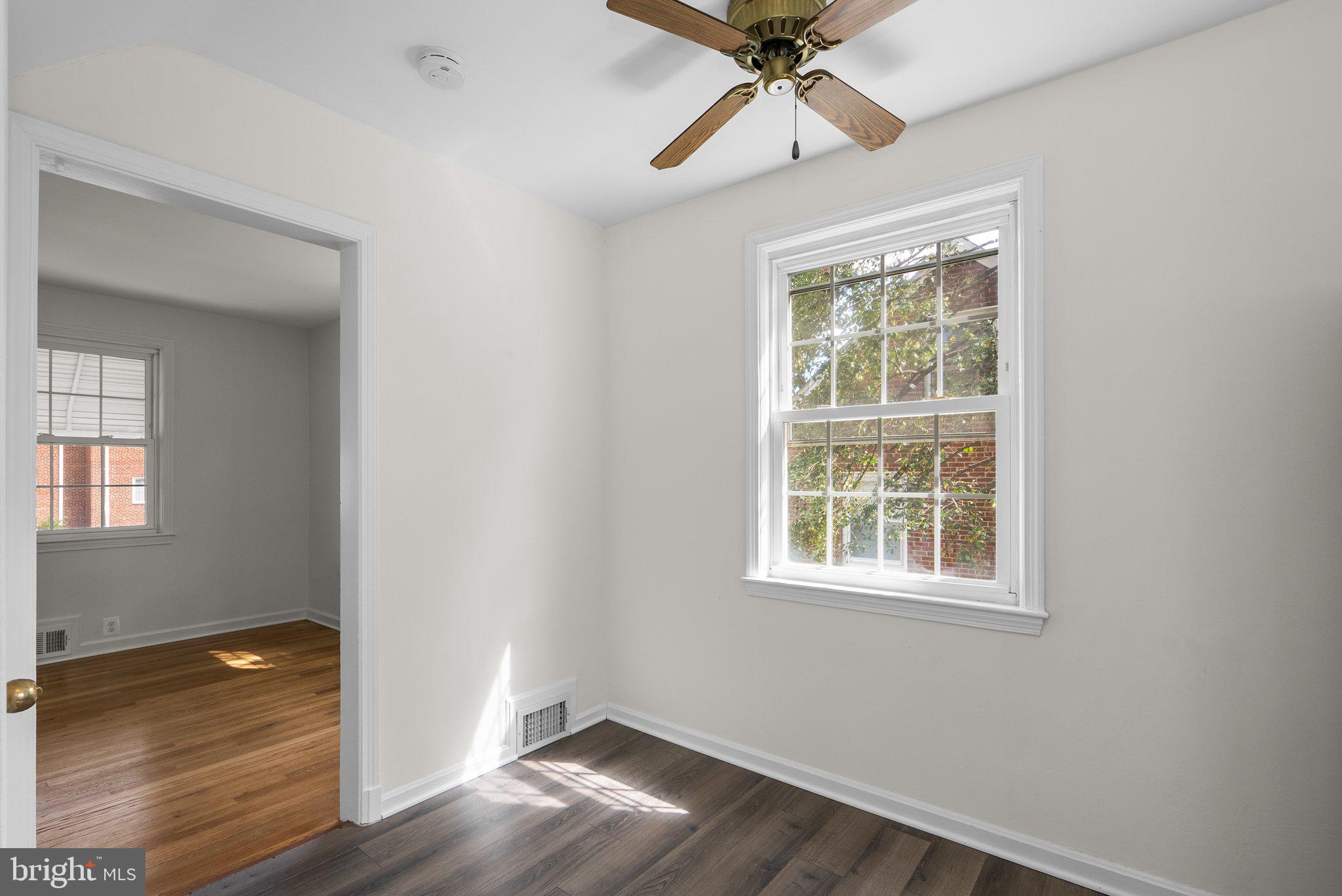 10110 McKenney Avenue Silver Spring, MD 20902 - Photo 17 of 56 an empty room with wooden floor fan and windows
