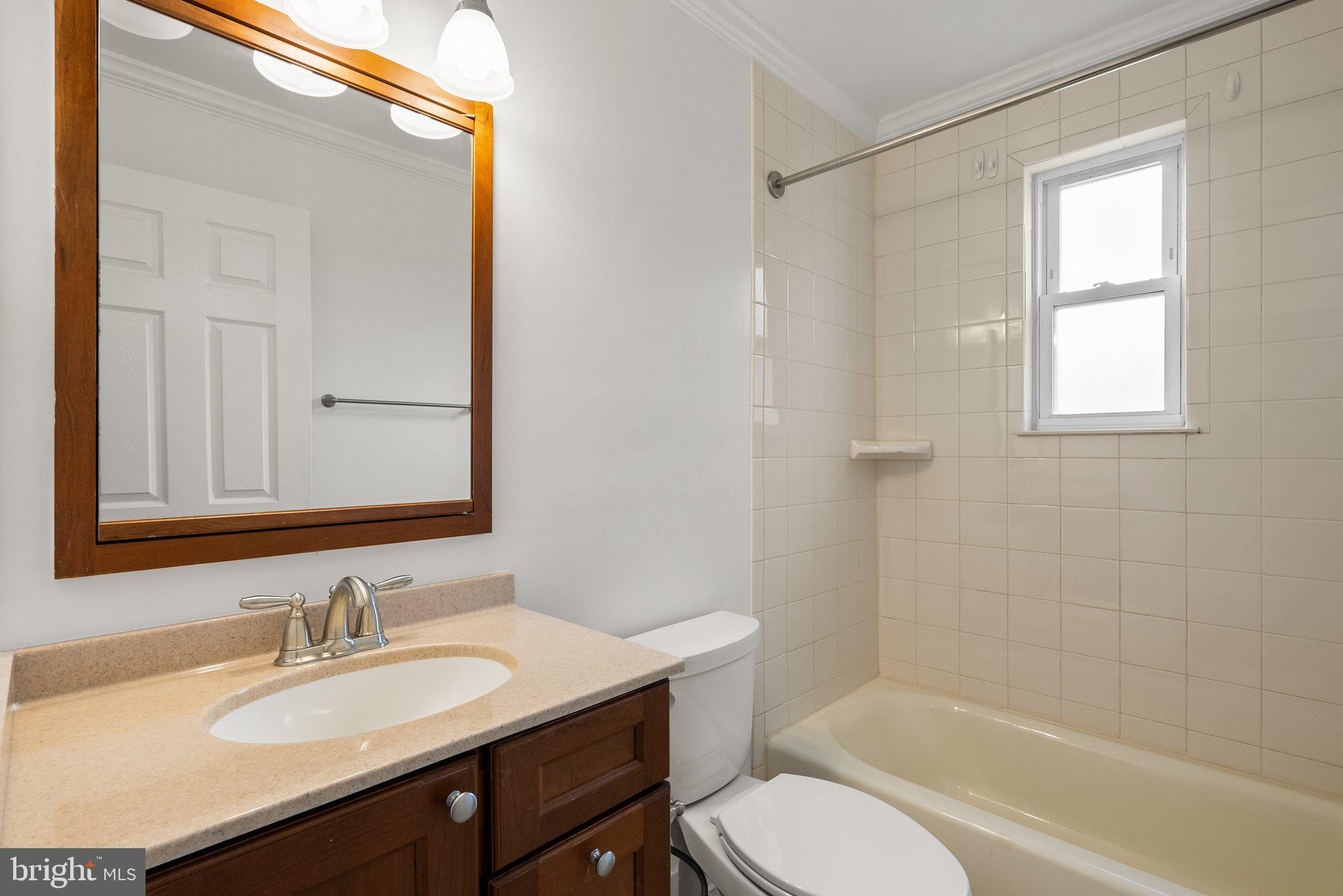 10110 McKenney Avenue Silver Spring, MD 20902 - Photo 22 of 56 a bathroom with a granite countertop sink toilet a mirror and shower