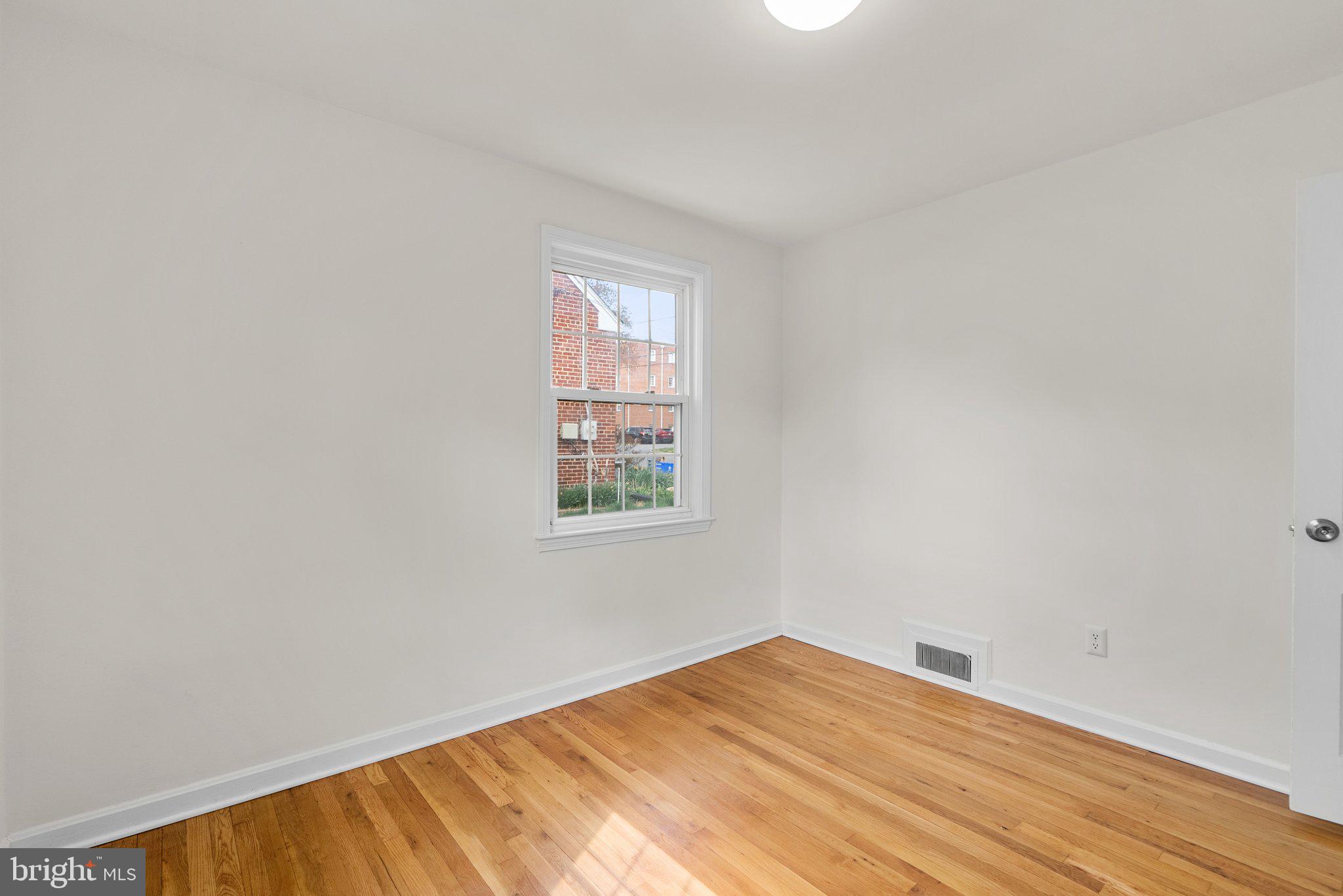 10110 McKenney Avenue Silver Spring, MD 20902 - Photo 25 of 56 an empty room with wooden floor and windows