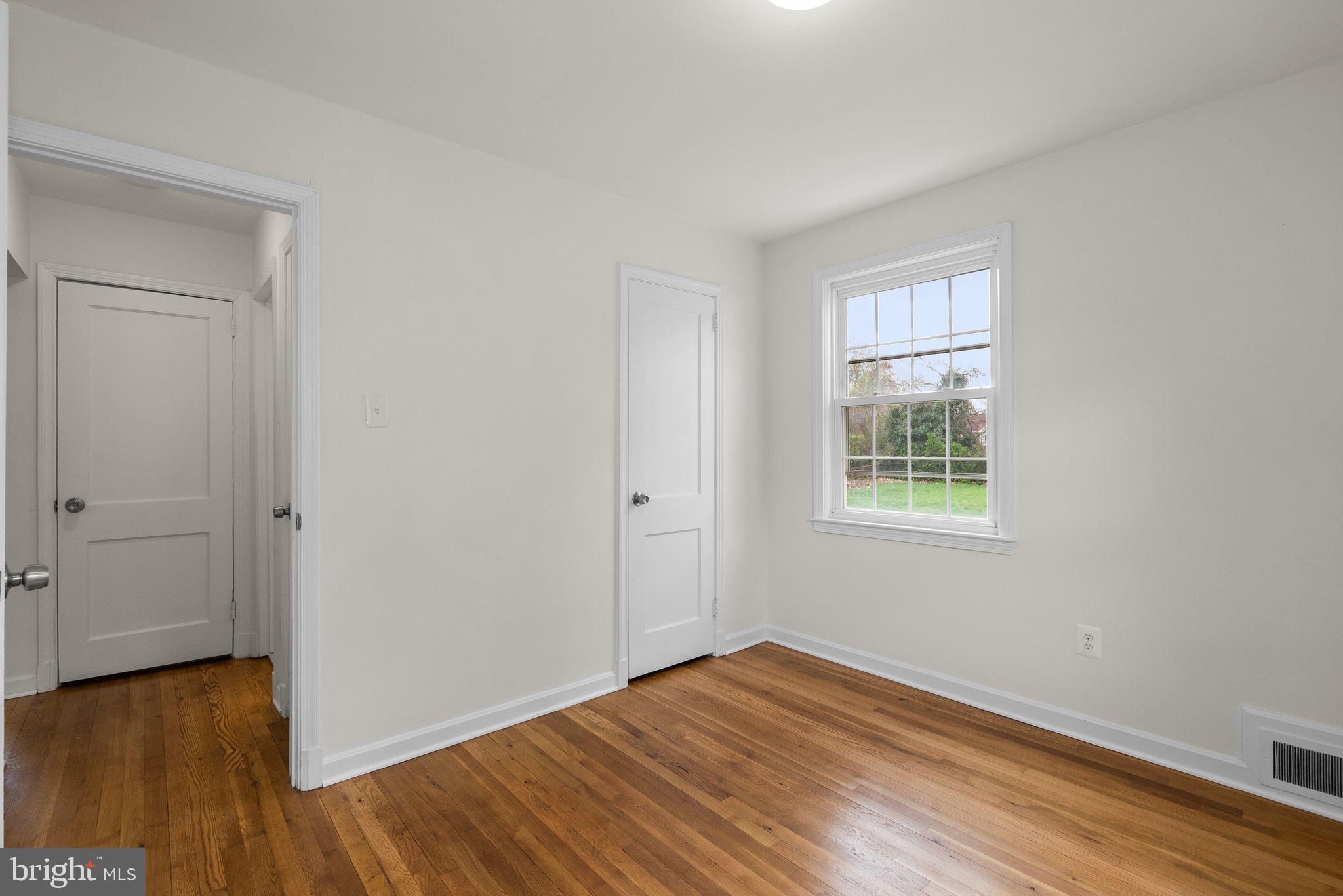 10110 McKenney Avenue Silver Spring, MD 20902 - Photo 26 of 56 an empty room with wooden floor and windows