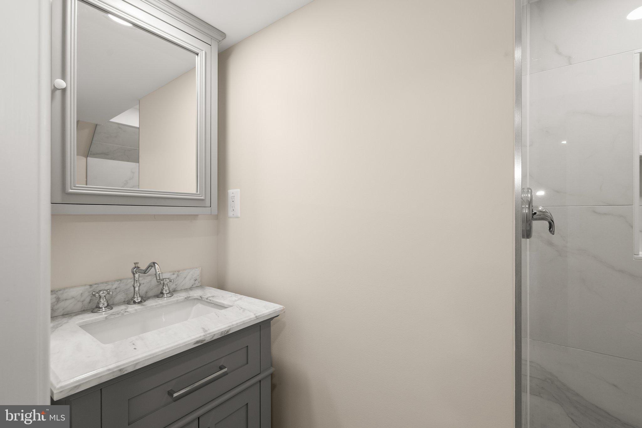 10110 McKenney Avenue Silver Spring, MD 20902 - Photo 36 of 56 a bathroom with a granite countertop sink and a mirror