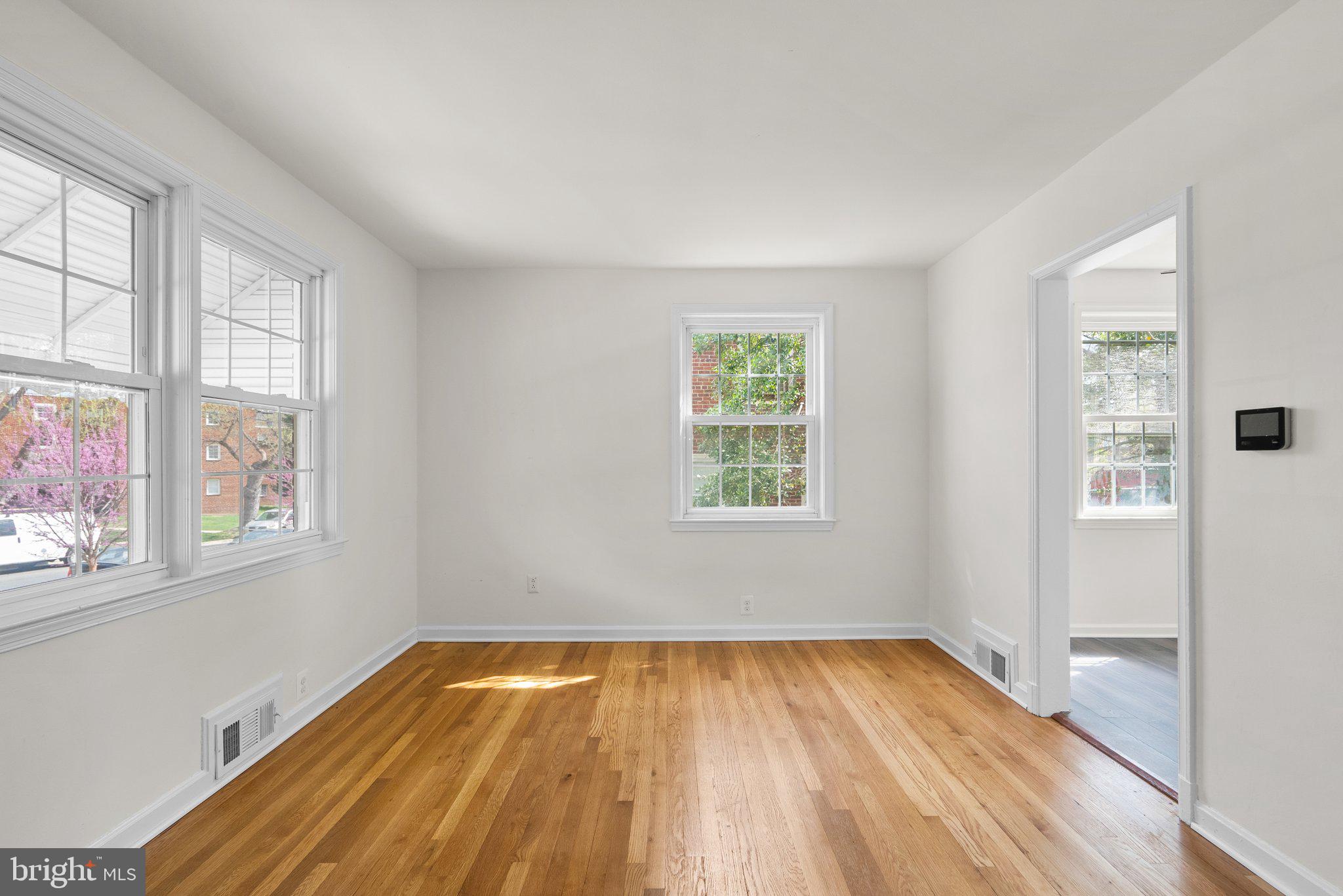 10110 McKenney Avenue Silver Spring, MD 20902 - Photo 6 of 56 an empty room with wooden floor and windows
