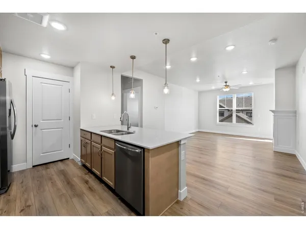 a kitchen with a sink and wooden floor