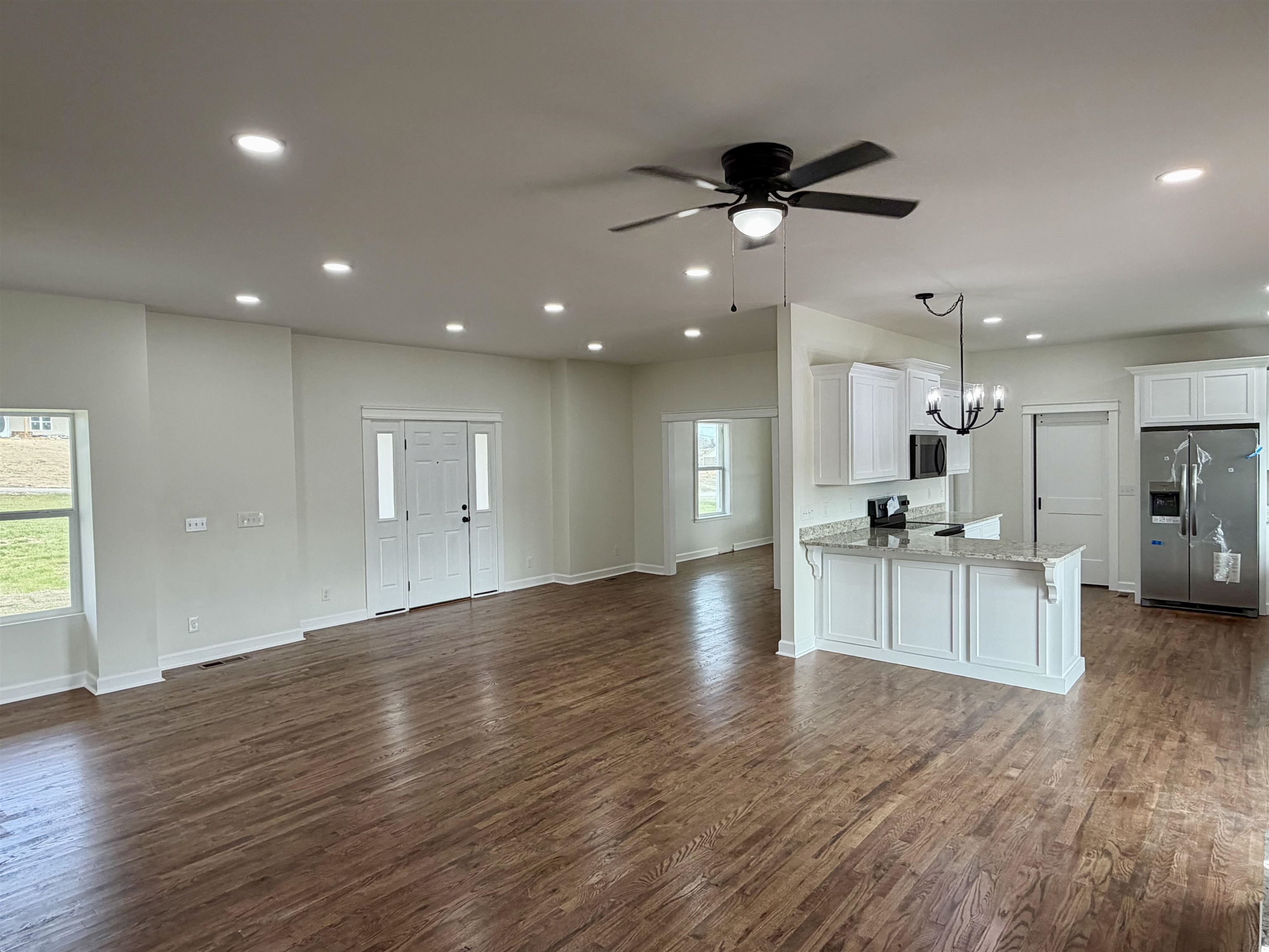 172 New Bethel Road Selmer, TN 38375 - Photo 7 of 30 an empty room with wooden floor a ceiling fan and kitchen view