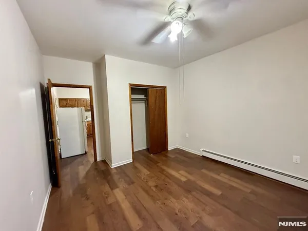 an empty room with closet and a chandelier fan