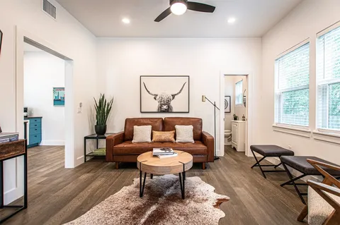 a living room with furniture a flat screen tv and kitchen view