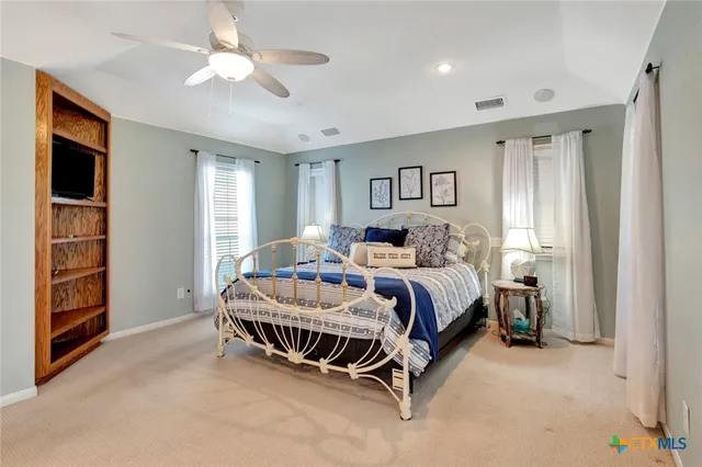 a spacious bedroom with a bed and a chandelier
