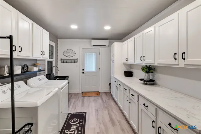 a kitchen with white cabinets and appliances