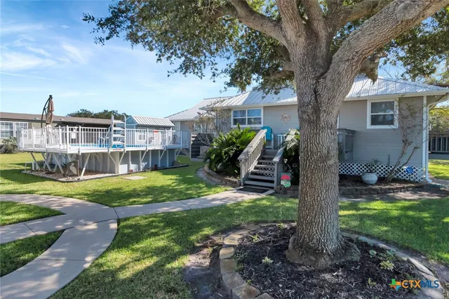 a view of a house with backyard and a tree