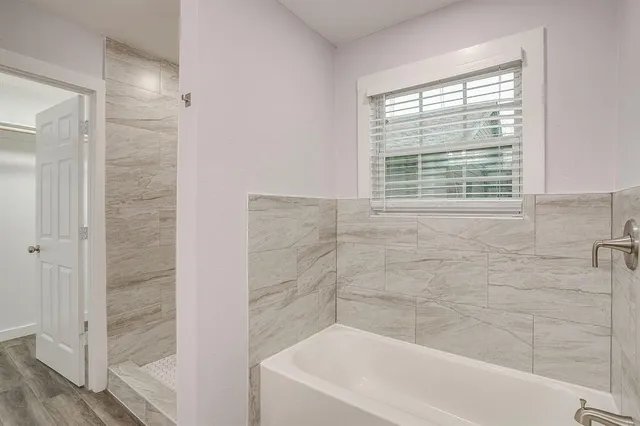 a bathroom with a bathtub and shower