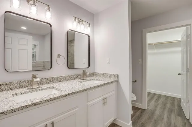 a bathroom with double vanity sinks and a mirror