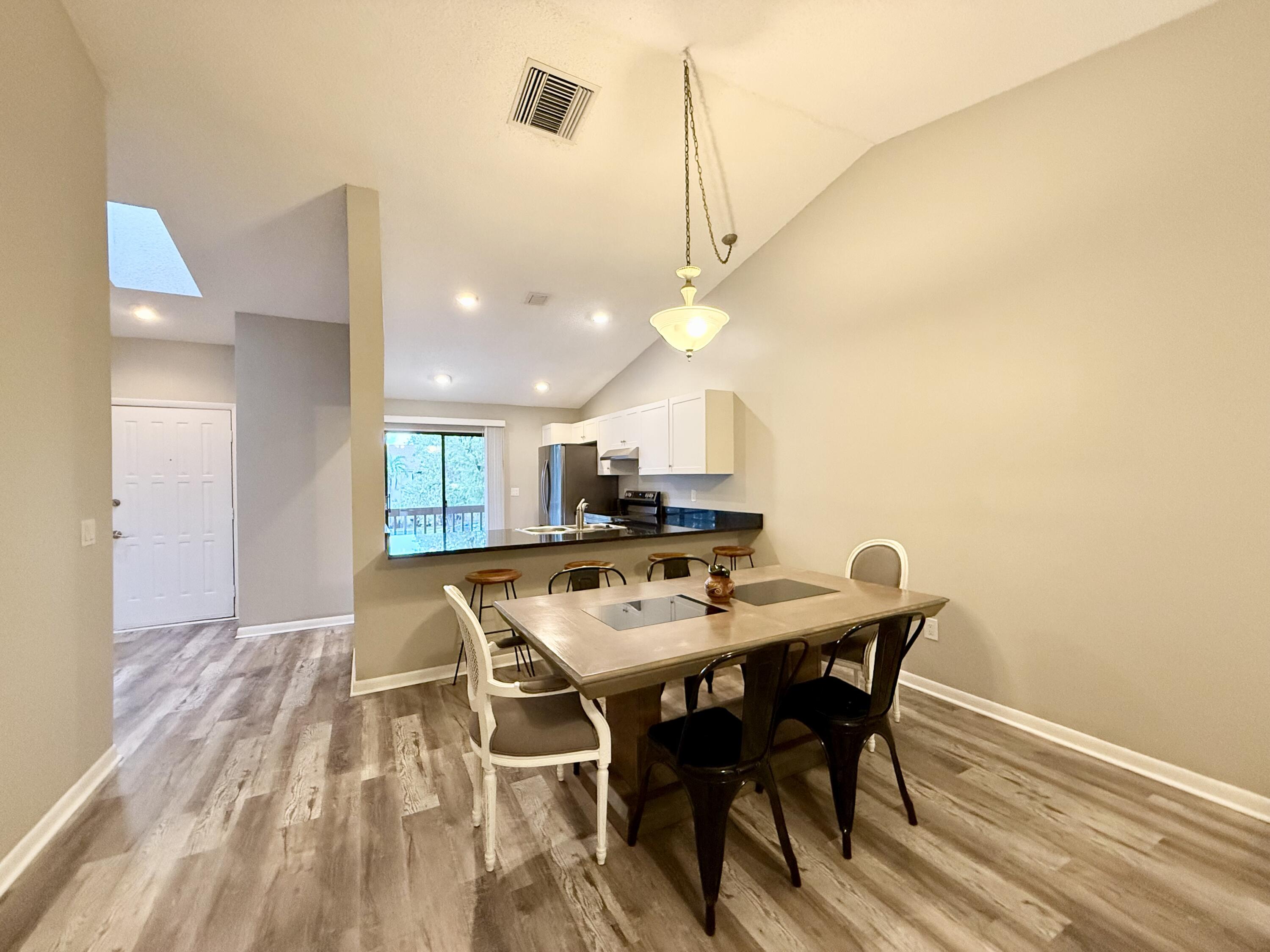 12969 Pennypacker Trail, Unit 15 Wellington, FL 33414 - Photo 4 of 24 a view of a dining room with furniture and wooden floor