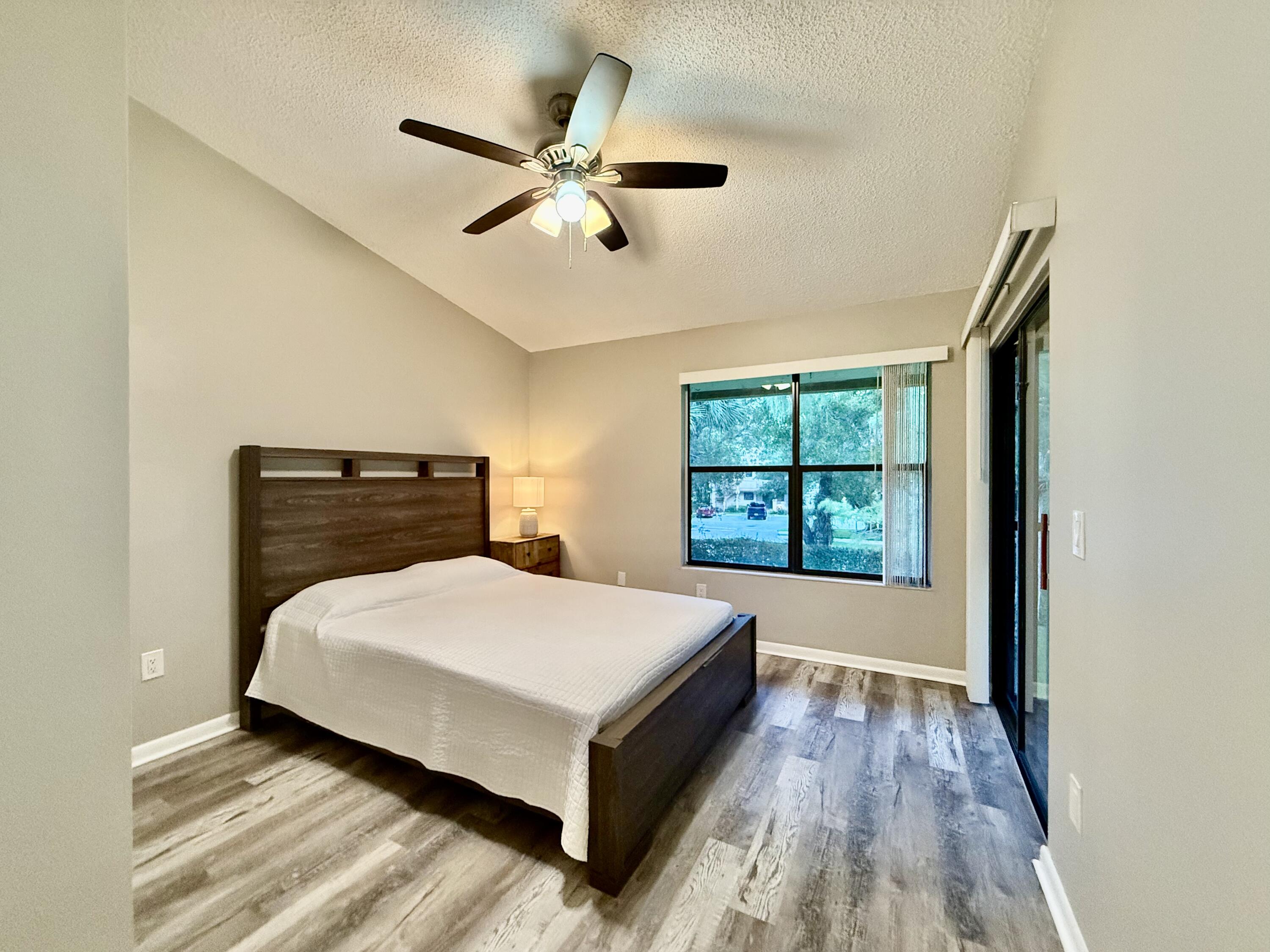 12969 Pennypacker Trail, Unit 15 Wellington, FL 33414 - Photo 8 of 24 a bedroom with a bed and window