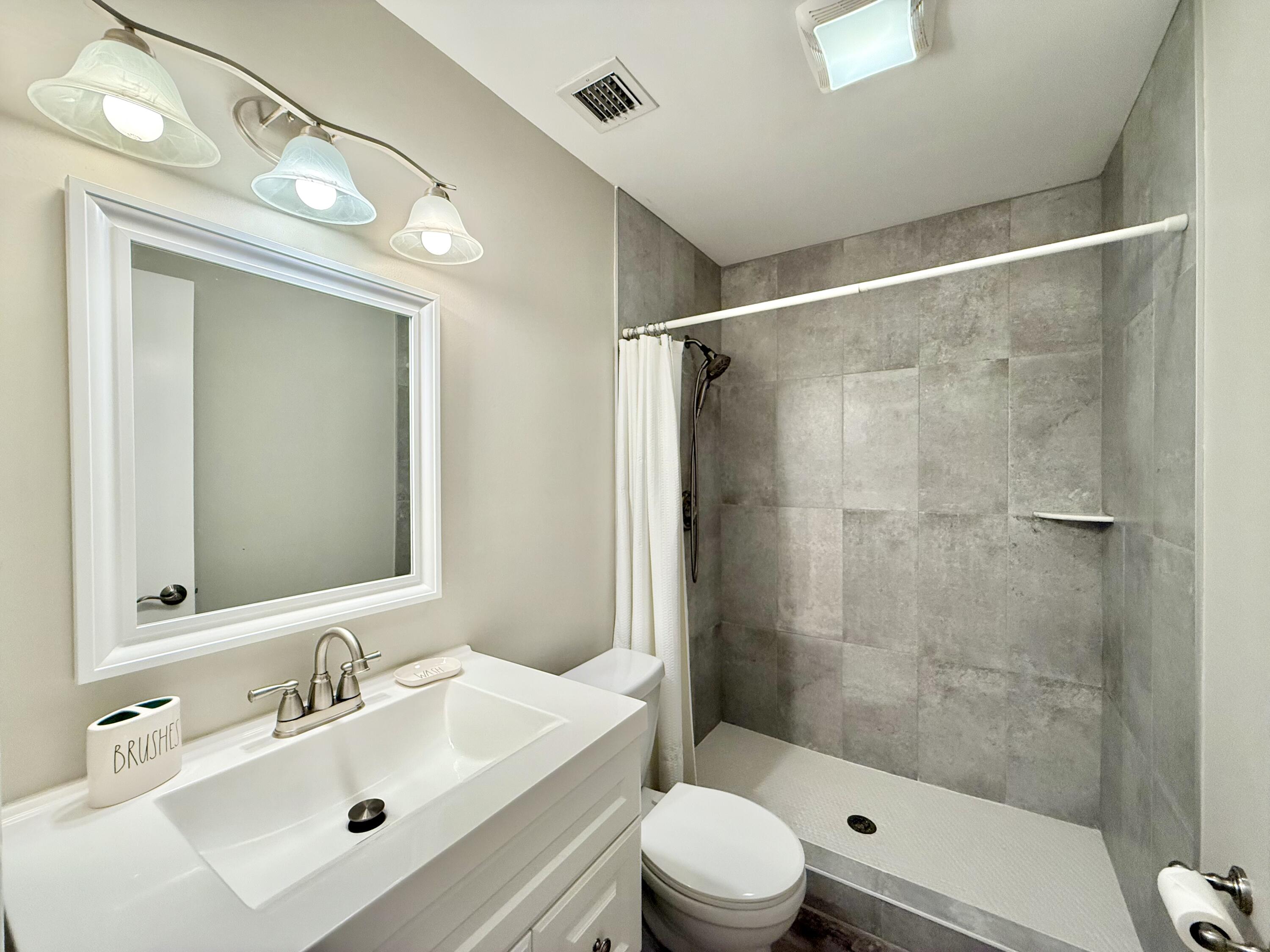 12969 Pennypacker Trail, Unit 15 Wellington, FL 33414 - Photo 9 of 24 a bathroom with a sink mirror shower and toilet
