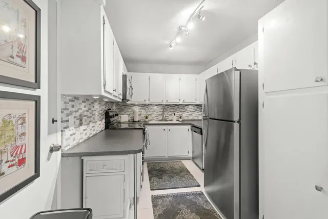 a kitchen with stainless steel appliances granite countertop a refrigerator and a stove