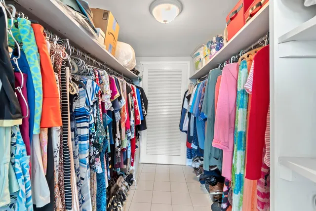 a view of walk in closet with clothes and shoes