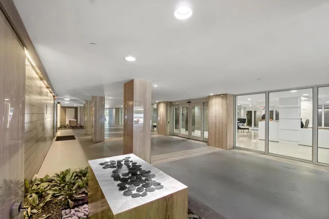 a living room with stainless steel appliances furniture a rug and a view of kitchen