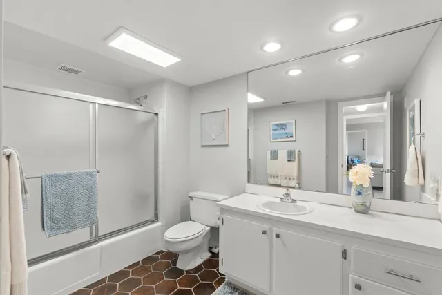 a spacious bathroom with a shower sink vanity mirror and toilet
