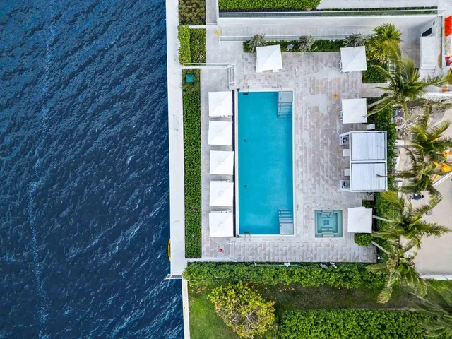a view of a backyard with couches under an umbrella