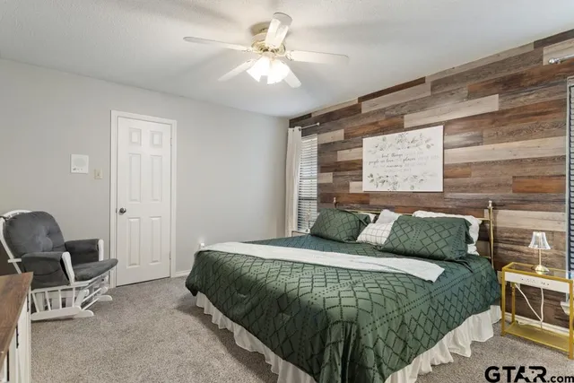 a bedroom with a bed a chair and potted plant