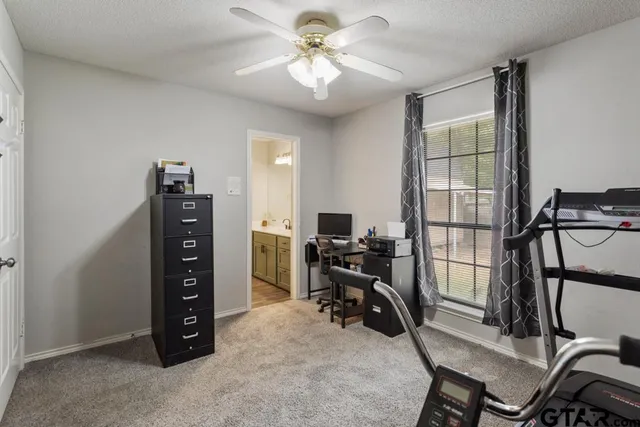 a view of a workspace with furniture and a window