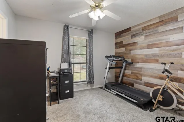 walk in closet with window and chandelier fan