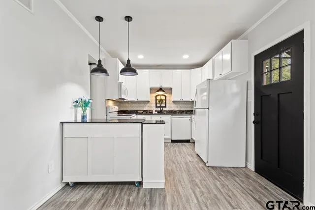 a kitchen with white cabinets and refrigerator