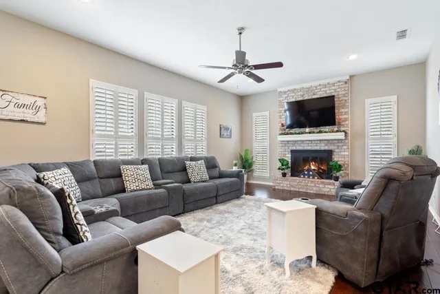 a living room with furniture a fireplace and a flat screen tv