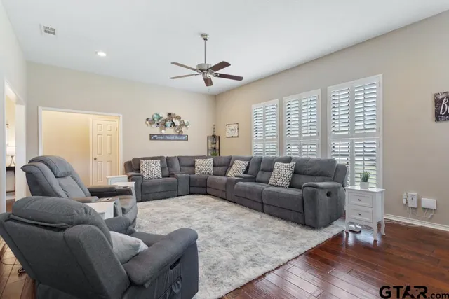 a living room with furniture a ceiling fan and a window