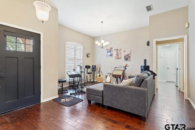 a living room with furniture wooden floor and a chandelier