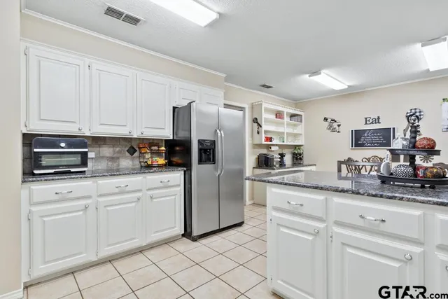 a kitchen with white cabinets and refrigerator