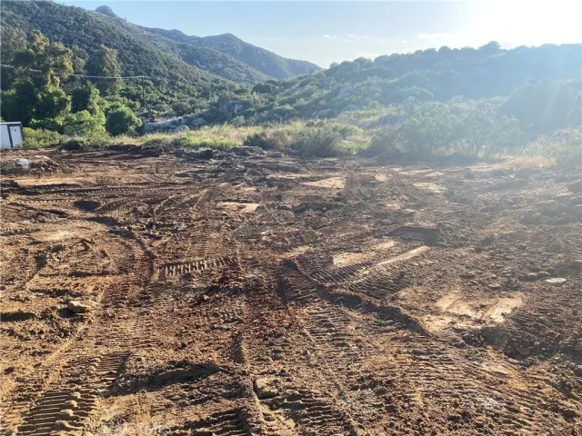 a view of a dry yard with mountains in the background